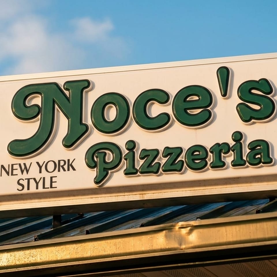 Noce's Pizzeria New York Style sign with green letters against a blue sky.